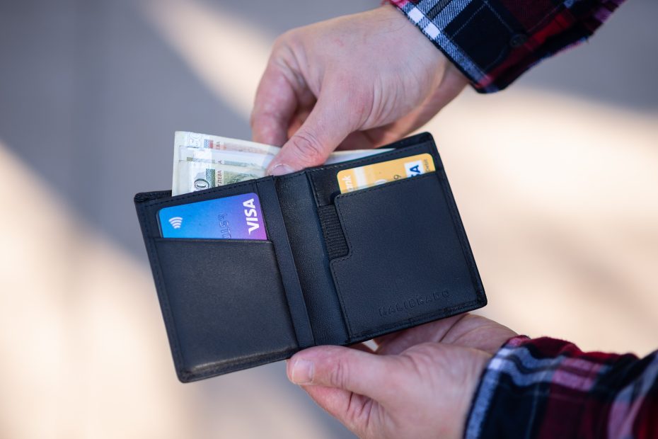 An image of a person holding a wallet and taking money out of it