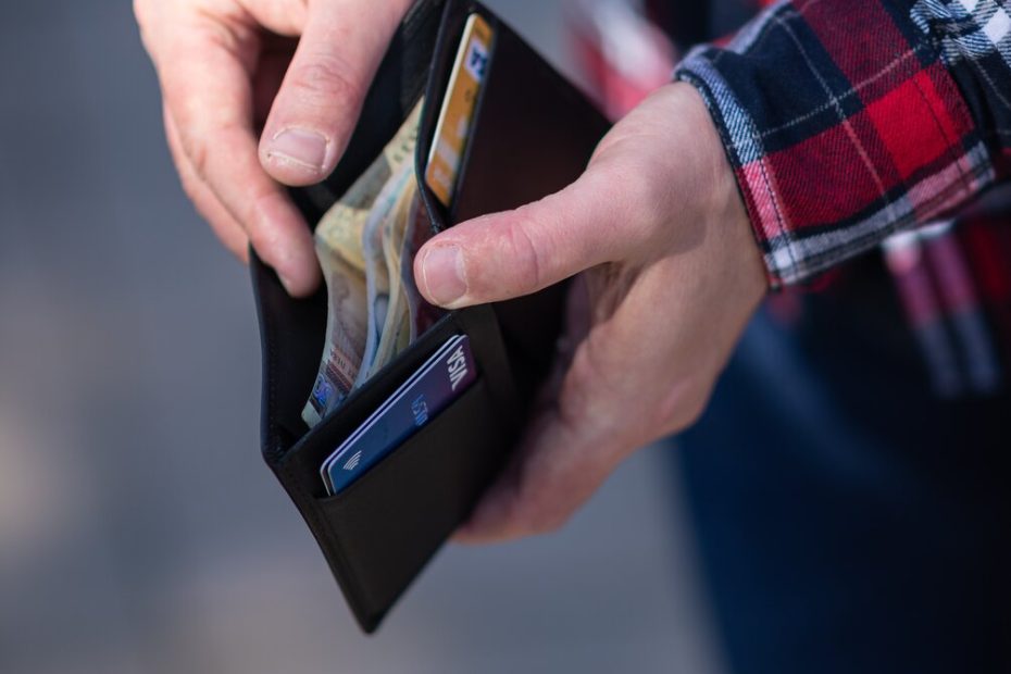 An image of a man holding his wallet open